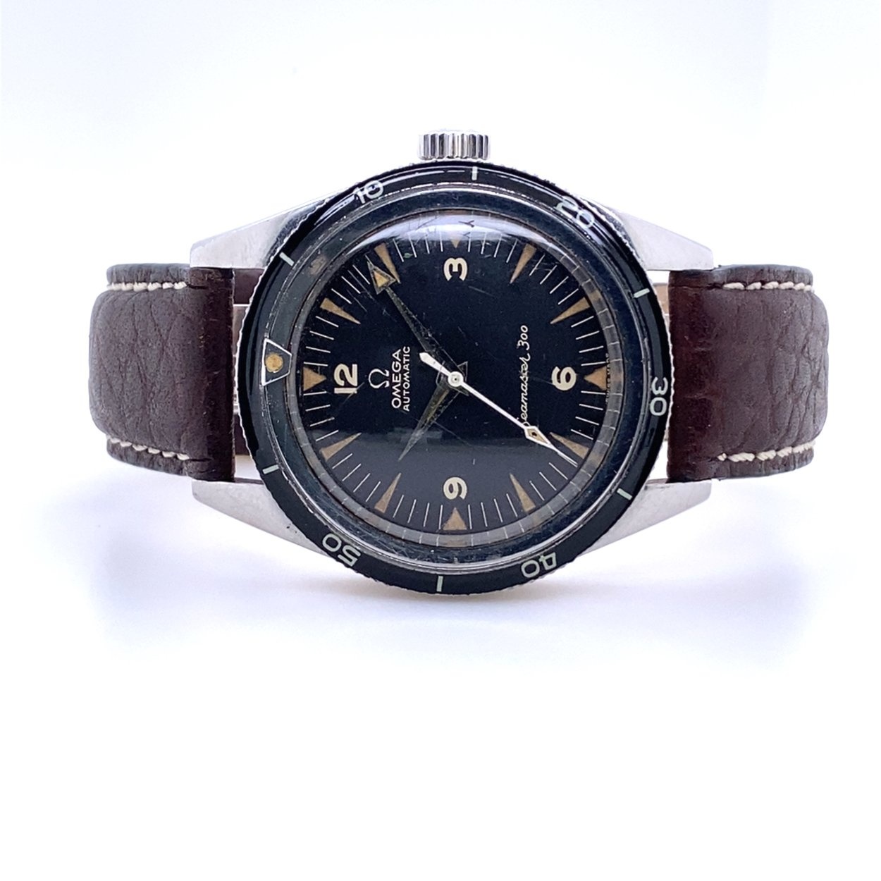Second-generation Seamaster 300, shown turned on its side, on a brown leather strap: thin Bakelite bezel with lume dot, matte black dial with luminous triangle indexes and Arabic 3-6-9-12, dauphine and arrow hands (no broad arrow). Dr. Crott gives ref. CK14.755-61 SC with caliber 552. · Photo: Dr. Crott · © Dr. Crott, used with permission · Source: https://uhren-muser.de/en/archives/104/53392